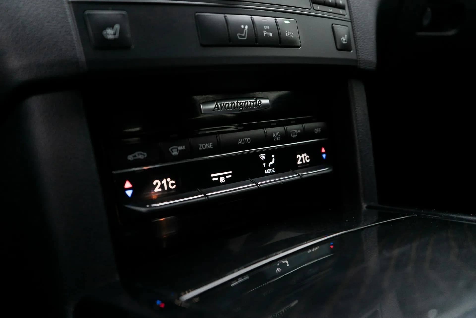 Bedienfeld der Klimaautomatik im Fahrzeuginnenraum mit zwei Temperaturanzeigen von 21 Grad